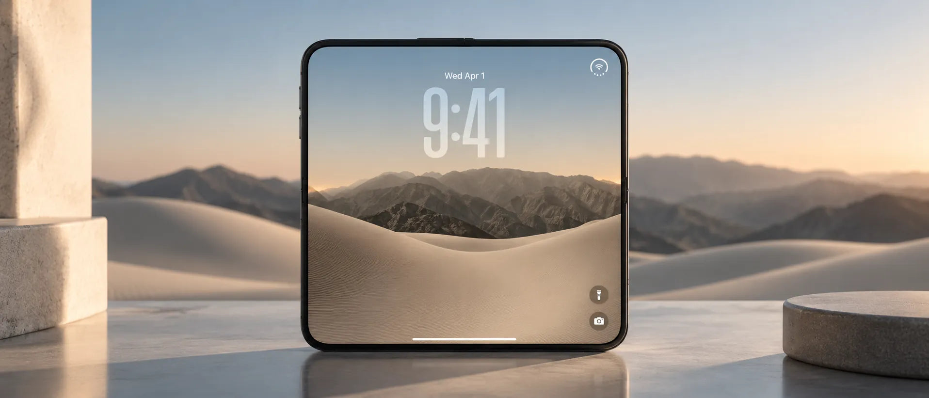 An iPhone Duo opened flat and facing forward on stone, dunes and mountains behind